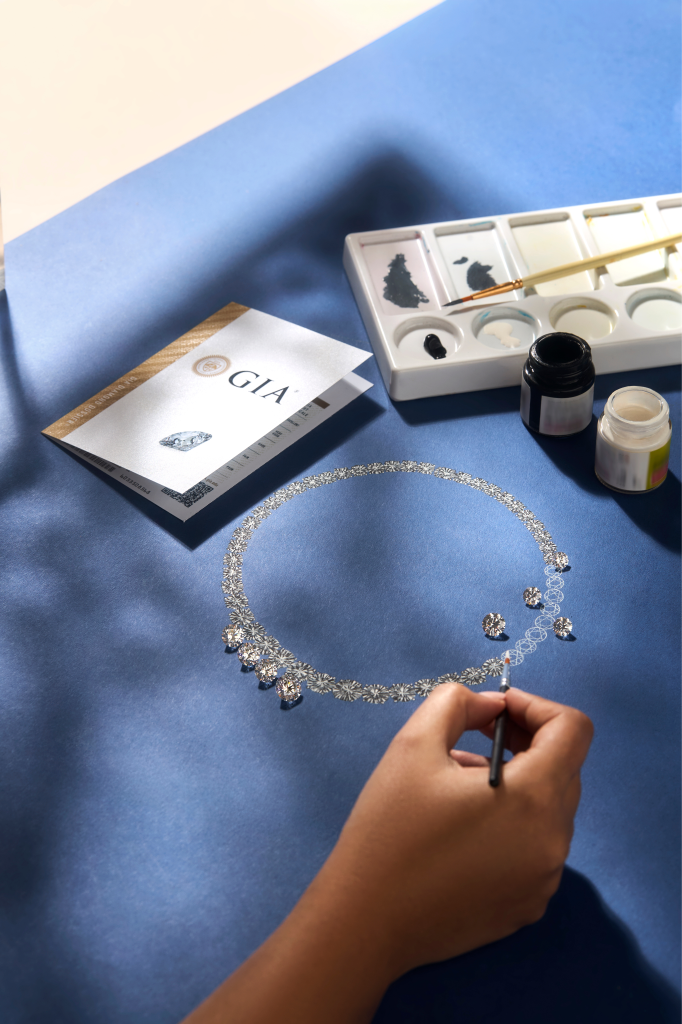 Grayscale image of a hand arranging diamonds on a surface.